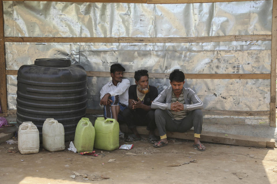 Rohingyas refugees sit outside their makeshift camp on the outskirts of Jammu, India, Sunday, March 7, 2021. Authorities in Indian-controlled Kashmir have sent at least 168 Rohingya refugees to a holding center in a process which they say is to deport thousands of the refugees living in the region. (AP Photo/Channi Anand)