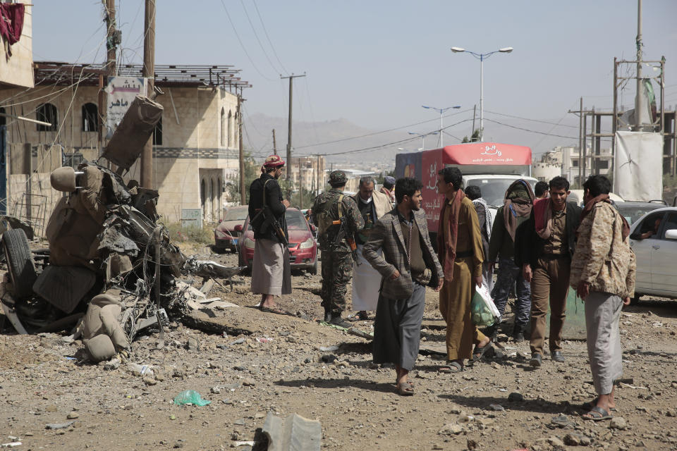 FILE - People inspect the site of an airstrike by Saudi-led coalition in Sanaa, Yemen, on Nov, 11, 2021. The United Nations is predicting that a record 274 million people – who together would amount to the world’s fourth most-populous country – will require emergency humanitarian aid next year in countries including Afghanistan, Ethiopia, Myanmar, Syria and Yemen as they face a raft of challenges such as war, insecurity, hunger, climate change and the coronavirus pandemic. (AP Photo/Hani Mohammed)