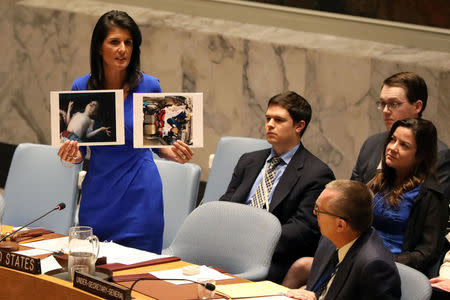 U.S. Ambassador to the United Nations Nikki Haley holds photographs of victims during a meeting at the United Nations Security Council on Syria at the United Nations Headquarters in New York City, NY, U.S. April 5, 2017. REUTERS/Shannon Stapleton