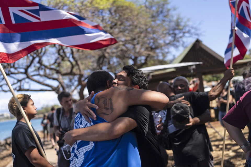 Residentes en Lahaina, Hawai, afectados por un letal incendio que arrasó la comunidad se abrazan tras una conferencia de prensa en Lahaina, Hawai, el 18 de agosto de 2023. (AP Foto/Jae C. Hong)