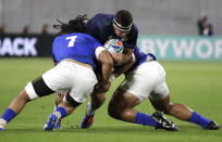 Scotland's Stuart McInally runs at Samoan defenders during the Rugby World Cup Pool A game at Kobe Misaki Stadium between Scotland and Samoa in Kobe City, Japan, Monday, Sept. 30, 2019. (AP Photo/Aaron Favila)