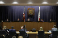 California Public Utilities Commission President Marybel Batjer, center rear, and commissioners listen as representatives of Pacific Gas and Electric Company (PG&E), seated at bottom, speak during a meeting at CPUC headquarters in San Francisco, Friday, Oct. 18, 2019. (AP Photo/Jeff Chiu)