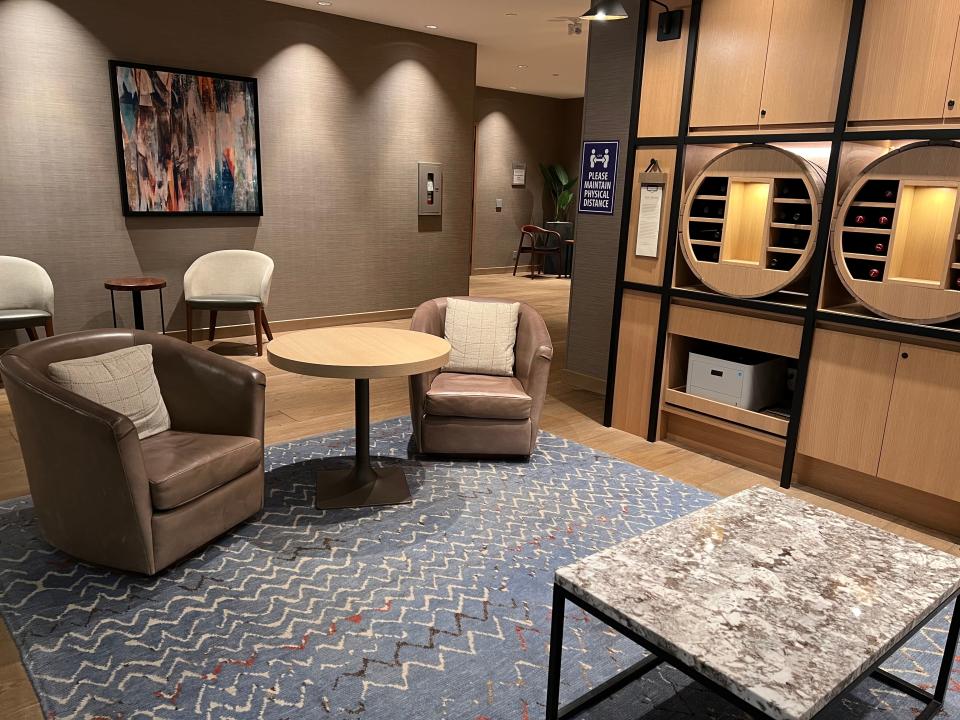 Hotel lobby with brown seating, dim lighting, and a blue rug