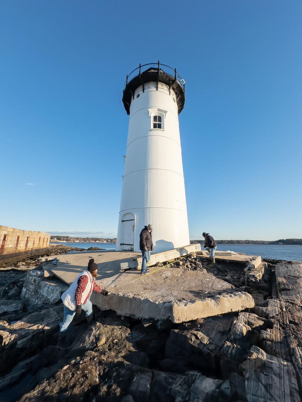 Michelle Shaw, Jeremy D'Entremont and Bob Trapani survey the extensive damage done to the base of the Portsmouth Harbor Lighthouse during two storms in January 2024.