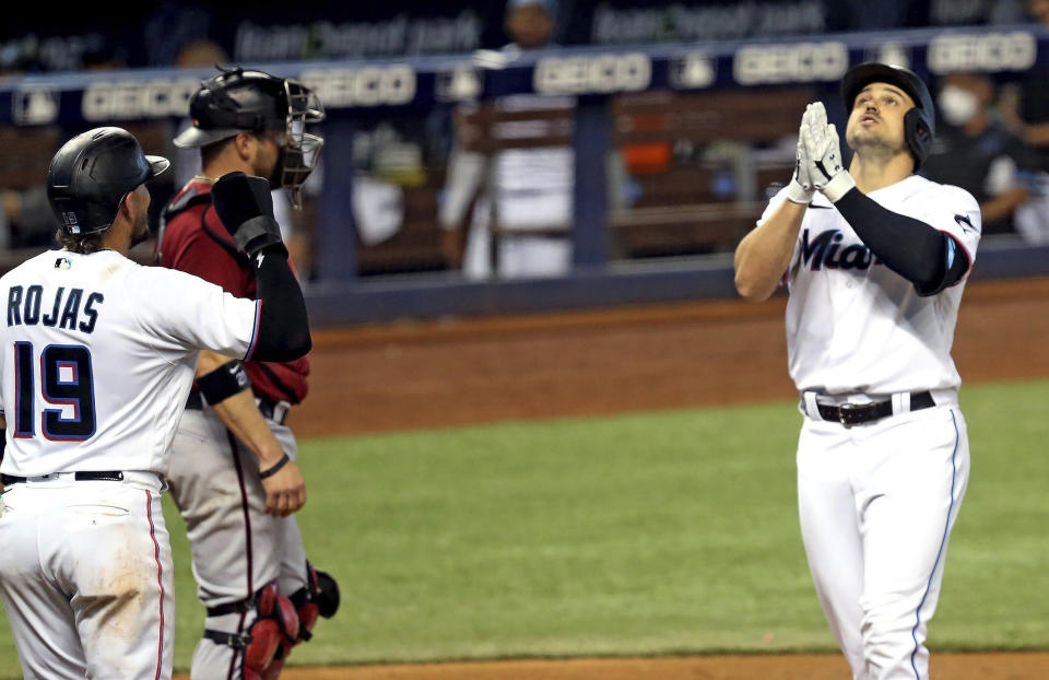 Miami Marlins Miguel Rojas (19) waits for Adam Duvall (14) after Duvall hit a three run home run during the second inning of a baseball game against the Arizona Diamondbacks, Wednesday, May 5, 2021 in Miami. (Charles Trainor Jr./Miami Herald via AP)