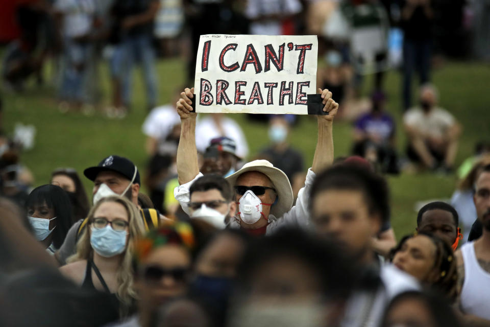 A man holds up a sign as he listens to the Rev. Al Sharpton address the crowd at a Juneteenth rally in Tulsa, Okla., Friday, June 19, 2020. Juneteenth marks the day in 1865 when federal troops arrived in Galveston, Texas, to take control of the state and ensure all enslaved people be freed, more than two years after the Emancipation Proclamation. (AP Photo/Charlie Riedel)