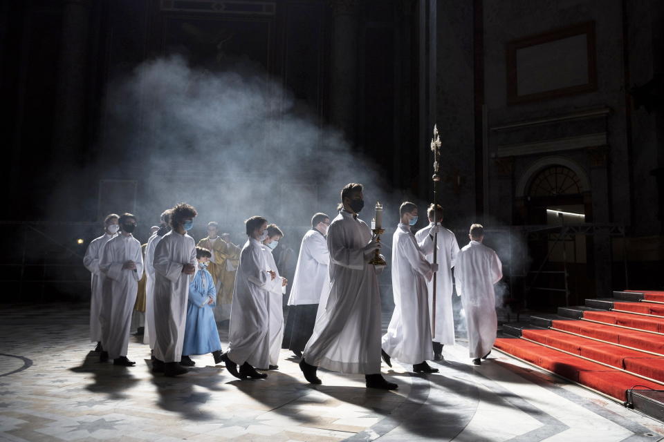 Clergyman and servers arrive for the Easter Sunday Mass celebrated by Primate of the Hungarian Catholic Church, Archbishop of Esztergom-Budapest, Cardinal Peter Erdo in the Esztergom Basilica in the City of Esztergom, Hungary, Sunday, April 4, 2021, during the pandemic coronavirus. The mass was broadcast on the Facebook account of the Archdiocese of Esztergom-Budapest and by a television channel as due to the pandemic of the novel coronavirus COVID-19 church services are not allowed to be attended by the public in Hungary. (Marton Monus/MTI via AP)
