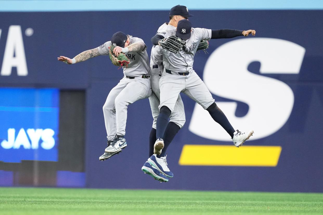 Apr 17, 2024; Toronto, Ontario, CAN; New York Yankees left fielder Alex Verdugo (24), center fielder Aaron Judge (99) and right fielder Juan Soto (22) celebrate the win against the Toronto Blue Jays at the end of the ninth inning at Rogers Centre. Mandatory Credit: Nick Turchiaro-USA TODAY Sports