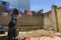 Reby hangs laundry outside her home in Beni, eastern Congo, on Saturday, May 1, 2021. In 2019, she met World Health Organization Dr. Boubacar Diallo, of Canada, when he came into a mobile phone shop where she was working. He asked her to talk about “important things” with him in a hotel and gave her $100 for “transport costs,” she told the AP. “My God, a beautiful girl like you who gets $60 a month is not enough,” he said, according to Reby. “You are a big girl and if you sleep with me, you are going to be a high-ranking member of the Ebola response in Beni and you are going to receive around $800 a month.” She said she refused Diallo’s offer, but continued to see him when he came into her shop. “From that day on, he always called me the difficult girl,” she said. (AP Photo/Kudra Maliro)