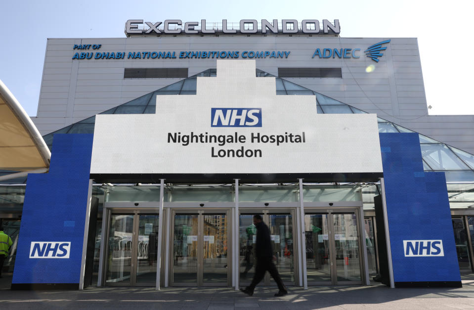 A man walks outside the Excel Centre, London while it is being prepared to become the NHS Nightingale hospital as the spread of the coronavirus disease (COVID-19) continues, in East London, Britain, March 27, 2020. REUTERS/Simon Dawson