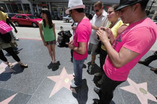 Tourists stop to take photos of Michael Jackson's star on the Hollywood Walk of Fame in Hollywood, California June 22, 2011. Fans were allowed to place flowers at singer's mausoleum at the Forest Lawn Memorial Park just outside Los Angeles, where he died from an overdose of powerful sedative propofol on June 25, 2009, aged 50