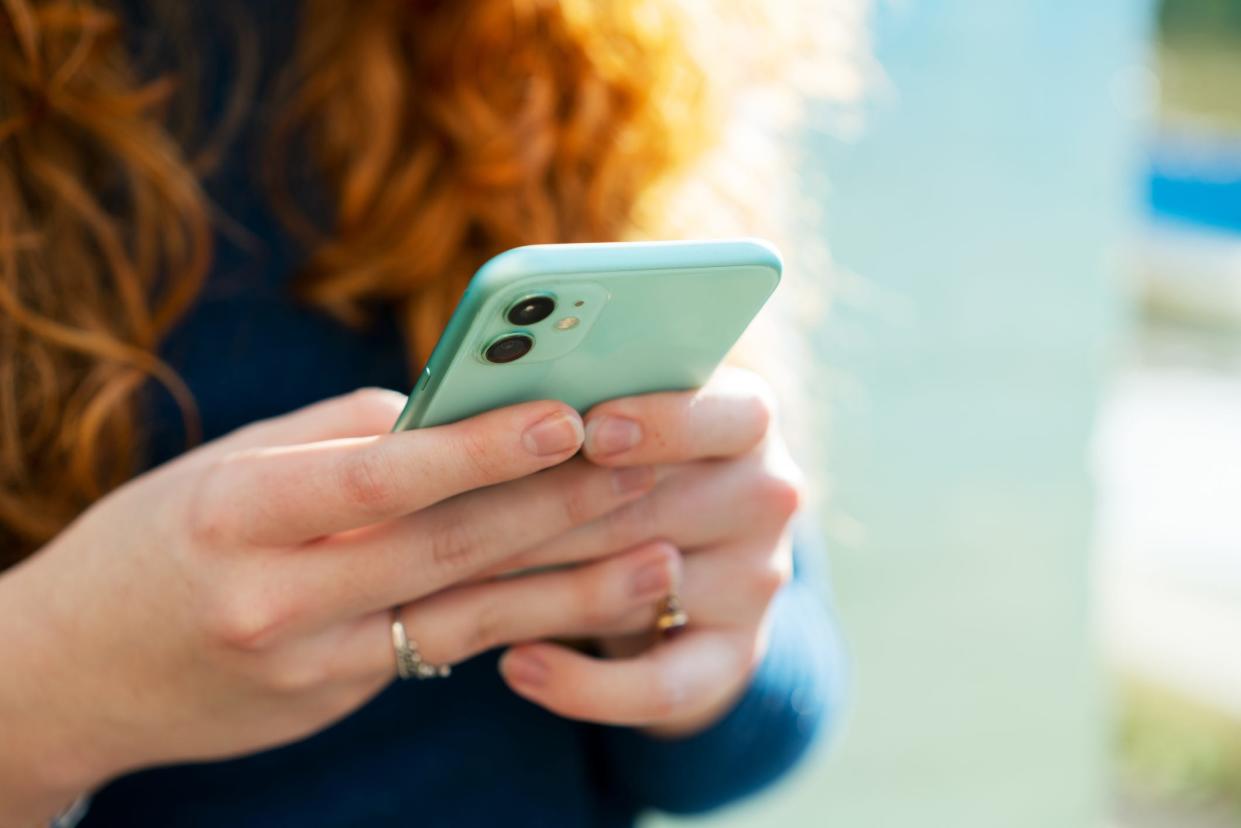 a woman typing and texting on her phone