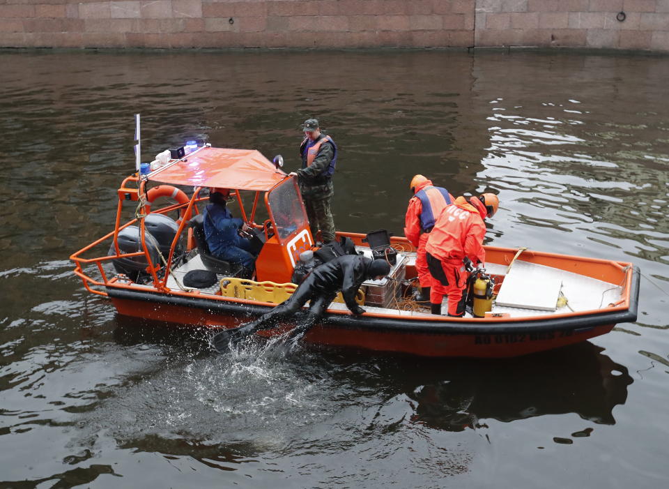 Rescuers examine the bottom of the Moika River.