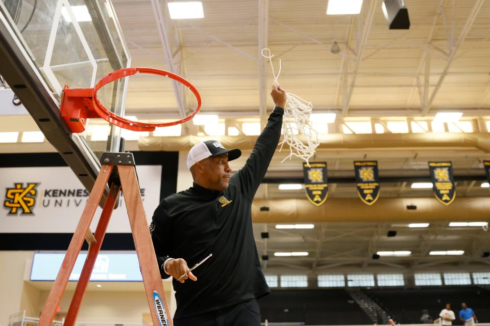 Kennesaw State head coach Amir Abdur-Rahim reacts to fans as he holds the net after defeating Liberty for the Atlantic Sun Conference title.