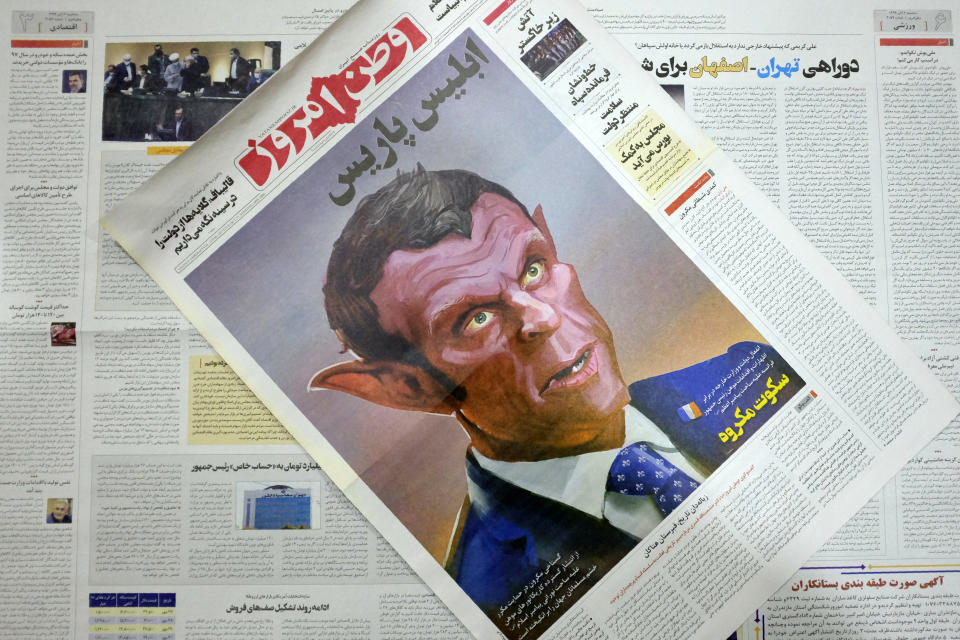 The front page of the Tuesday, Oct. 27, 2020 edition of the Iranian hard-line Iranian newspaper, Vatan-e Emrooz, depicts French President Macron as the devil and called him Satan in a cartoon. Iran summoned a French diplomat to protest Macron's staunch support of secular laws that deem caricatures depicting the Prophet Muhammad as protected under freedom of speech. (AP Photo/Vahid Salemi)