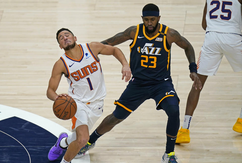 Phoenix Suns guard Devin Booker (1) drives around Utah Jazz forward Royce O'Neale (23) during the second half of an NBA basketball game Thursday, Dec. 31, 2020, in Salt Lake City. (AP Photo/Rick Bowmer)