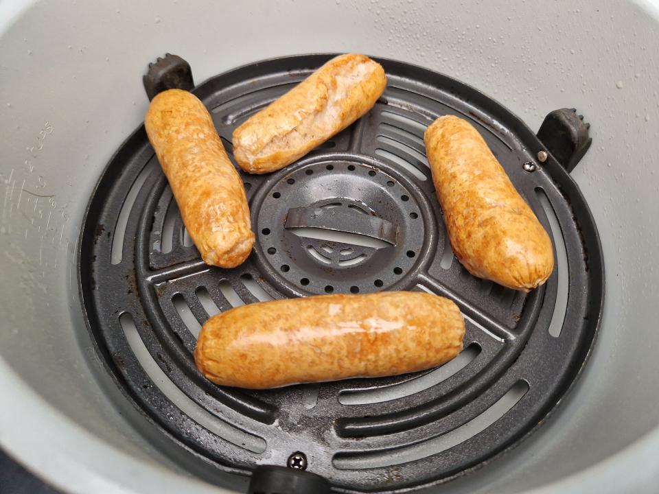 four cooked sausage links in an air fryer
