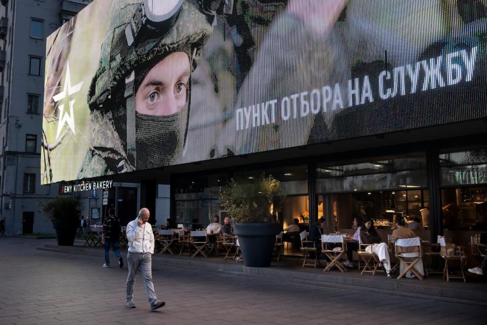 A man walks past a Russian armed forces recruitment ad in the centre of Moscow, Russia on Thursday, Sept. 28, 2023.