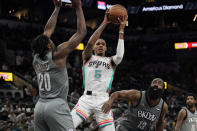 San Antonio Spurs guard Dejounte Murray (5) looks to pass as he is pressured by Brooklyn Nets center Day'Ron Sharpe (20) and guard James Harden (13) during the second half of an NBA basketball game, Friday, Jan. 21, 2022, in San Antonio. (AP Photo/Eric Gay)