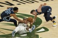 Milwaukee Bucks' Khris Middleton looks to pass with Memphis Grizzlies' Desmond Bane and Grayson Allen defending during the first half of an NBA basketball game Saturday, April 17, 2021, in Milwaukee. (AP Photo/Morry Gash)