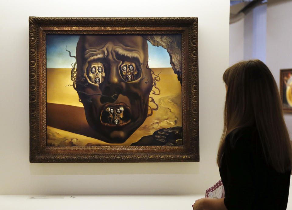 A visitor looks at a painting entitled 'Le visage de la guerre' (The face of war') (1940) by Spanish surrealist artist Salvador Dali during an exhibition devoted to his work at the Centre Pompidou contemporary art center (aka Beaubourg) on November 19, 2012 in Paris. More than 30 years after the first retrospective in 1979, the event gathers more than 200 art pieces and runs until March 13, 2013. (FRANCOIS GUILLOT/AFP/Getty Images)