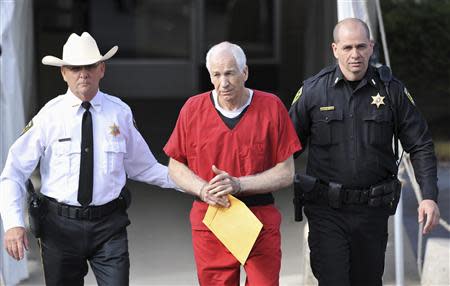 Jerry Sandusky (C) leaves the Centre County Courthouse after his sentencing in his child sex abuse case in Bellefonte, Pennsylvania October 9, 2012. REUTERS/Pat Little