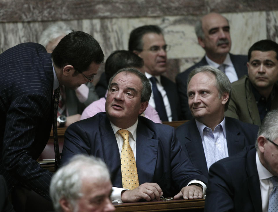 Former conservative Prime Minister Costas Karamnlis talks with lawmakers just before the speach of the leader of the Party Antonis in parliament on Friday, May 11, 2011. Greek political leaders are continuing power-sharing negotiations after a May 6 general election gave no party an outright majority to govern. Failure to reach a coalition agreement would trigger fresh general elections next month (AP Photo/Dimitri Messinis)