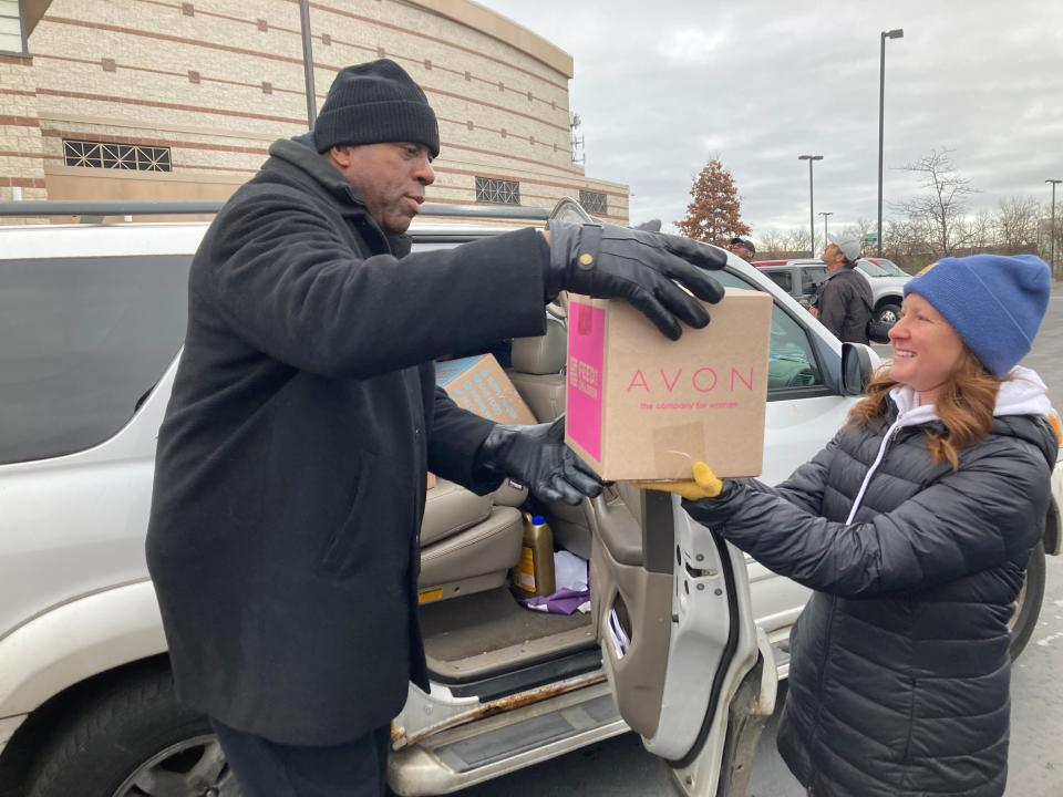 NBA legend Earvin "Magic" Johnson loads up a car at Detroit's Second Ebenezer Church where hundreds of families received goods as part of a giveaway hosted by Johnson and General Motors on Nov. 12, 2022.