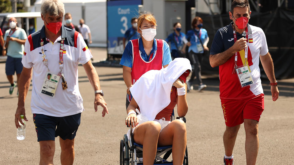 Paula Badosa of Team Spain is helped away from the court in a wheelchair due to heat stroke. (Photo by David Ramos/Getty Images)