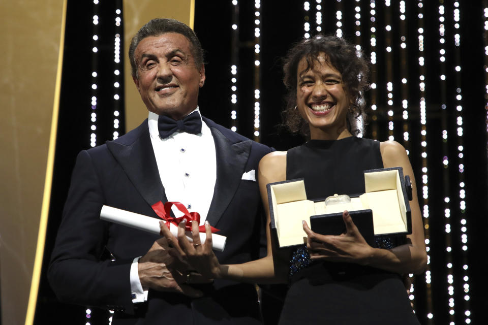 Director Mati Diop, right, holds the grand prix Palme d'Or award for the film 'Atlantique' presented by actor Sylvester Stallone during the awards ceremony at the 72nd international film festival, Cannes, southern France, Saturday, May 25, 2019. (Photo by Vianney Le Caer/Invision/AP)