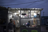 Syrians stand in a barber shop in the Kawergosk refugee camp in northern Iraq, Saturday, April 8, 2017. For the millions of Syrian refugees scattered across camps and illegal settlements across the region, the chemical attack on a town in northern Syria and subsequent U.S. strike was a rare moment when the world briefly turned its attention to Syria, before turning away again. (AP Photo/Felipe Dana)