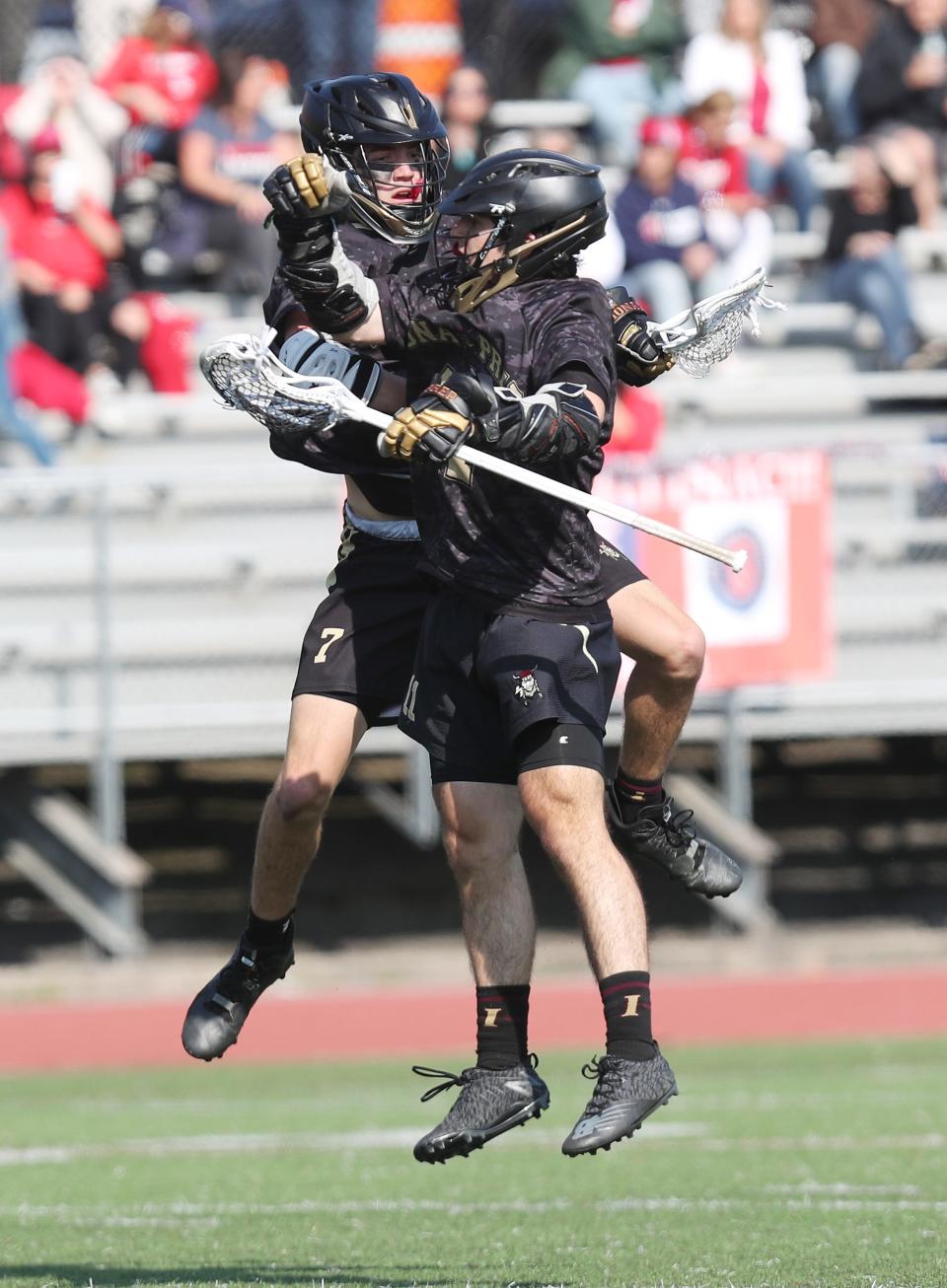 Iona's Brandon Blenk (7) and Blaise New (11) celebrate a second half goal against Stepinac during the CHSAA New York AA championship game at Archbishop Stepinac High School in White Plains May 18, 2023. Iona won the game 8-7.