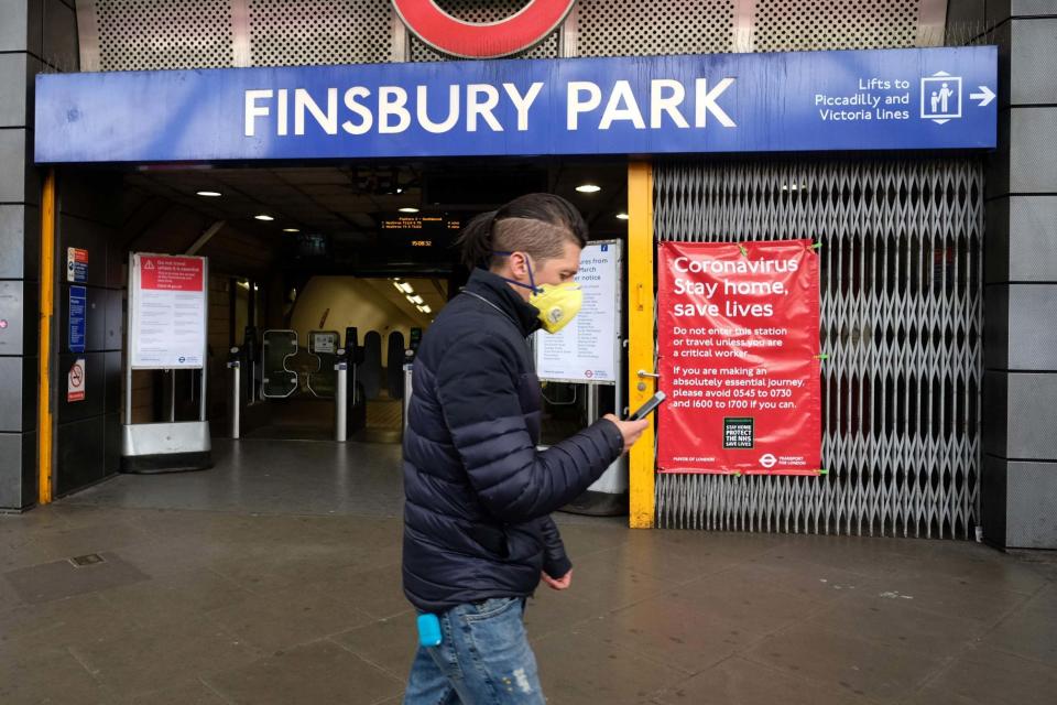 A man wearing a face mask walks past Finsbury Park station (AFP via Getty Images)