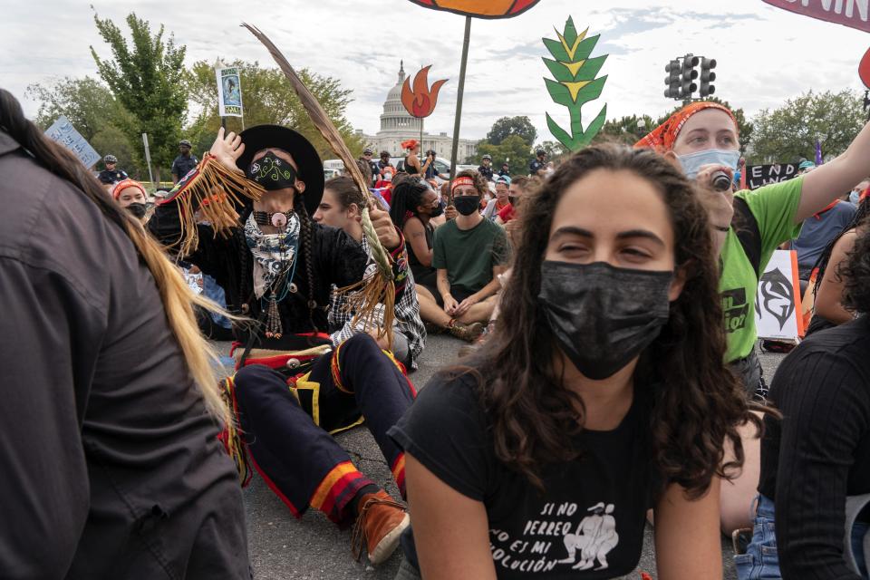 Ira Francisco, 21, of Chicago, left, who is Navajo and Ojibwe, joins a chant during an act of civil disobedience by the U.S. Capitol, Friday, Oct. 15, 2021, during a climate change protest including indigenous and youth activists, in Washington. "I stand with my people," says Francisco, "this is our land. Our ancestors fought for me and I will fight for the generations to come." (AP Photo/Jacquelyn Martin)