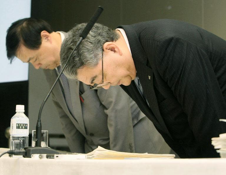 Tokyo Electric Power Company president Toshio Nishizawa (R) bows to apologize to victims of the nuclear accident at the Fukushima power plant during a press conference to announce the company's financial results in Tokyo on November 4, 2011