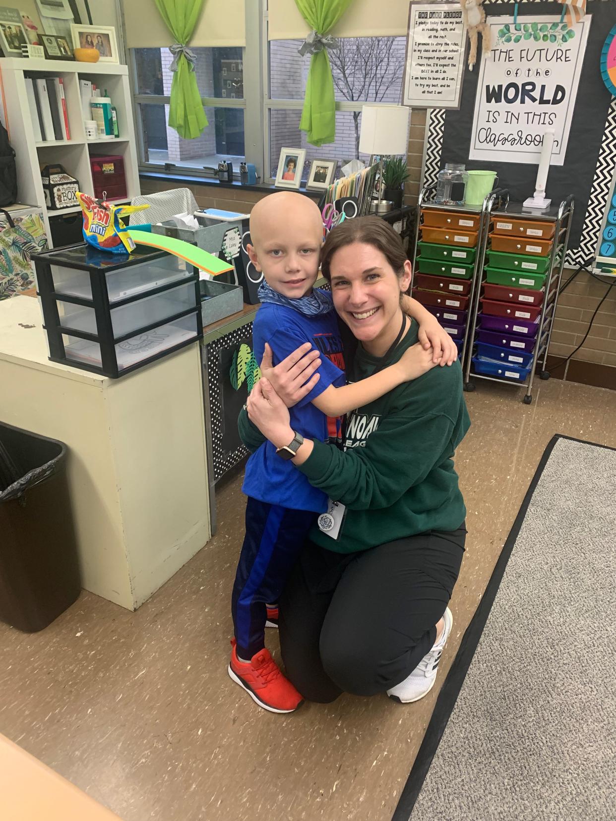 Blake Michel, who is undergoing treatment for cancer, hugs Plain Local Schools teacher Alexandra Cale who has supported her student through the process.