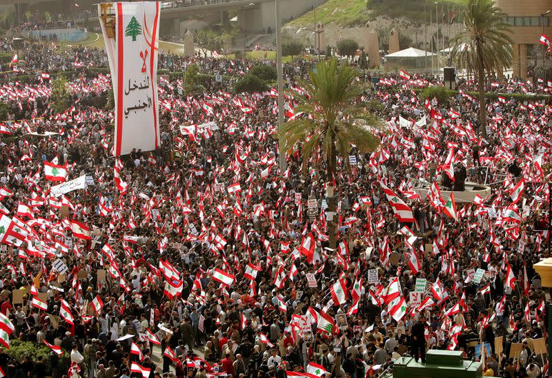 FILE PHOTO: Lebanese people wave flags as they gather for a pro-Syria rally in central Beirut