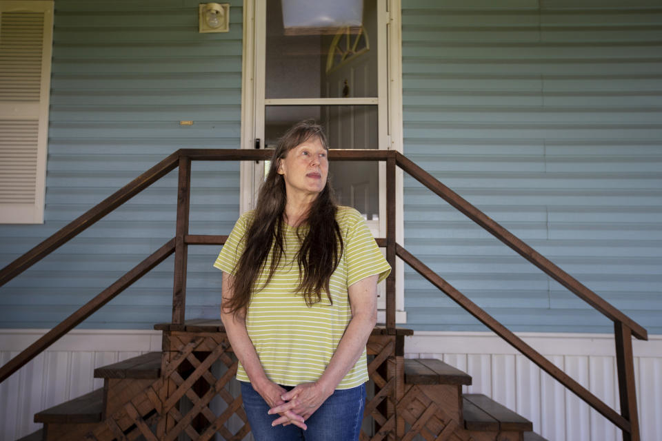 Jill Roberts poses for a portrait in front of her home in the Ridgeview Homes mobile home community in Lockport, N.Y., June 23, 2022. Roberts is one of the mobile home residents participating in a rent strike in reaction to a proposed rent increase being introduced by new owners of the property. Roberts, who has lived in her home since early 2020, says she has thought about leaving and is concerned about the clarity of the water in the park and recurring sewer issues. (AP Photo/Lauren Petracca)