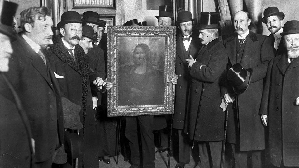 People gather around the Mona Lisa painting on January 4, 1914 in Paris; the painting was stolen from the Musée du Louvre by Vincenzo Peruggia in 1911. - Roger Viollet/Getty Images