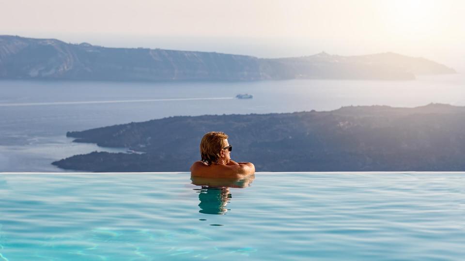 Man relaxing in infinity swimming pool.