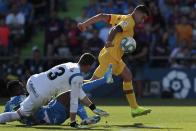 Barcelona's Luis Suarez, right, duels for the ball against Getafe's goalkeeper David Soria, foreground, and Getafe's Djene Dakonam during the Spanish La Liga soccer match between Getafe CF and FC Barcelona in Getafe, outskirts of Madrid, Spain, Saturday, Sept. 28, 2019. (AP Photo/Bernat Armangue)