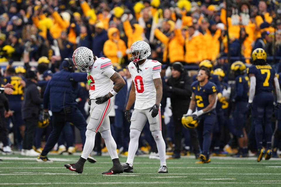 Ohio State receivers Emeka Egbuka (2) and Xavier Johnson walk off the field after a Michigan interception sealed Saturday's game.