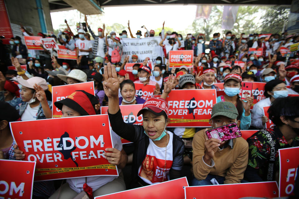 Anti-coup protesters flash the three-fingered salute as they gather outside the Hledan Centre in Yangon, Myanmar Friday, Feb. 19, 2021. The daily protests campaigning for civil disobedience in Myanmar are increasingly focusing on businesses and government institutions that sustain the economy. (AP Photo)