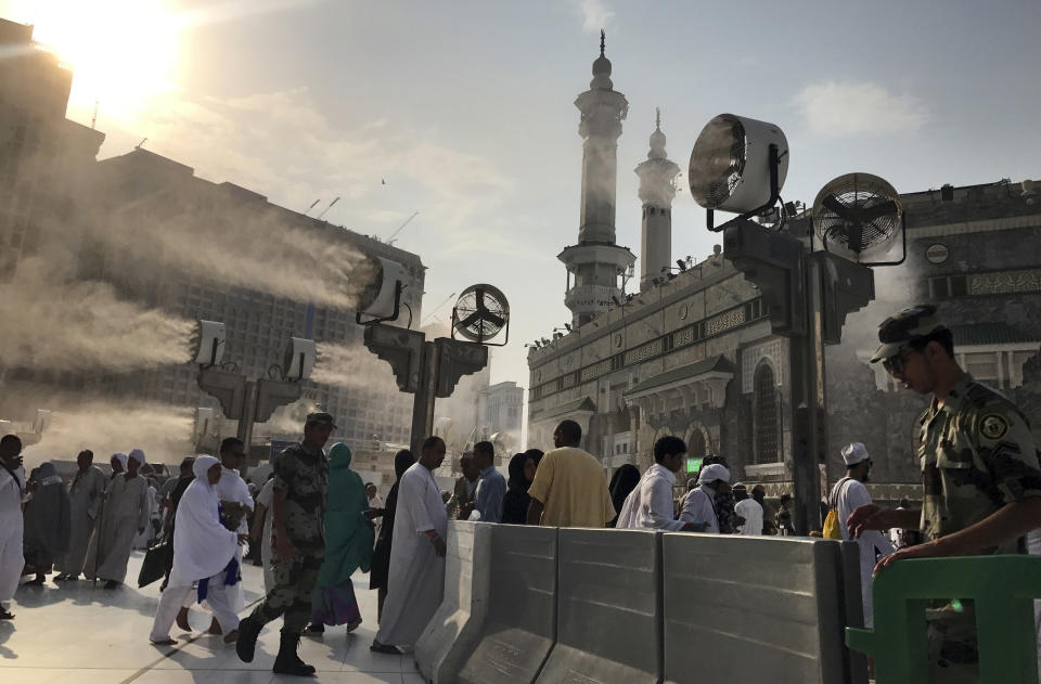 Large cooling fans spray water on pilgrims