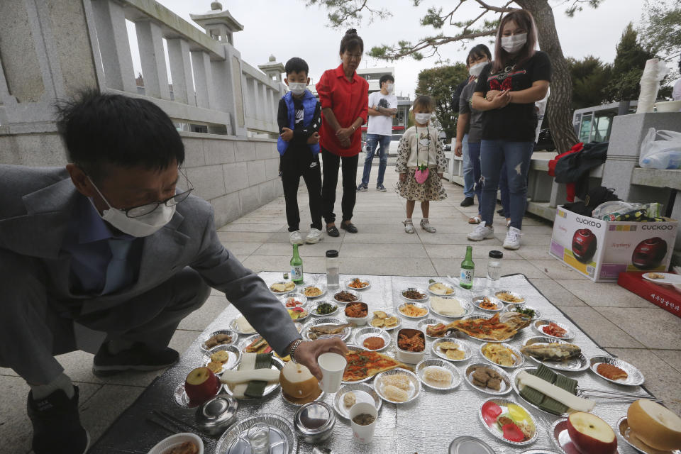 North Korean defector Han Hong-geun, left, and his family members pay respect to their ancestors in North Korea to celebrate the Chuseok, the Korean version of Thanksgiving Day, at Imjingak Pavilion in Paju, near the border with North Korea, South Korea, Thursday, Oct. 1, 2020. The government has discouraged people from visiting their hometowns for the Chuseok holiday amid concerns about the spread of the coronavirus. (AP Photo/Ahn Young-joon)