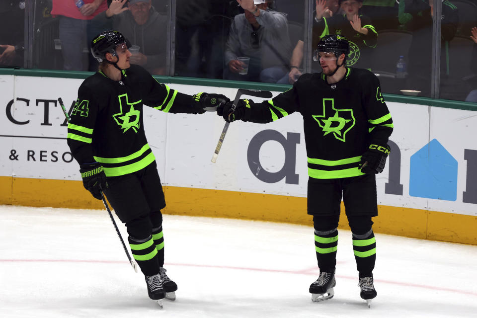 Dallas Stars center Roope Hintz (24) congratultes defenseman Miro Heiskanen (4) after he scored a goal during the third period in an NHL hockey game agains the Seattle Kraken, Saturday, April 13, 2024, in Dallas. (AP Photo/Richard W. Rodriguez)