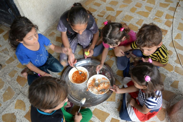 Grandchildren of 61-year-old Iraqi matriarch Sana Ibrahim share a meal in their family home in the northern city of Mosul