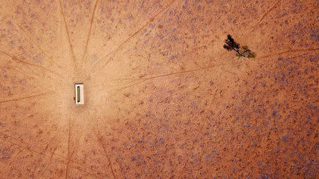 A lone tree stands near a water trough in a drought-effected paddock on Jimmie and May McKeown's property located on the outskirts of town of Walgett, in New South Wales, Australia, July 20, 2018. REUTERS/David Gray