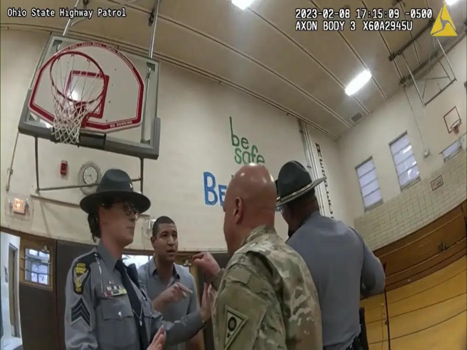 This photo provided by Ohio State Highway Patrol shows police bodycam footage of NewsNation correspondent Evan Lambert interaction with the leader of the Ohio National Guard Wednesday, Feb. 8, 2023 in the gymnasium of an elementary school in East Palestine, Ohio. (Ohio State Highway Patrol via AP)