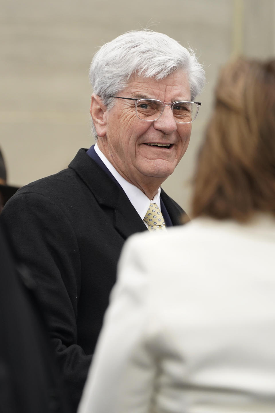 Former Mississippi Gov. Phil Bryant, speaks to other guests at the inauguration of Republican Gov. Tate Reeves on the steps of the Mississippi State Capitol in Jackson, Miss., Tuesday, Jan. 9, 2024. (AP Photo/Rogelio V. Solis)